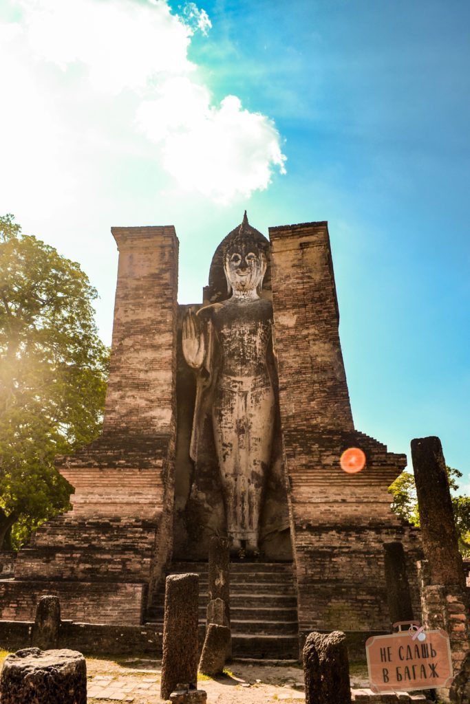 Статуя стоячего Будды слева и справа от чеди на территории Ват Махатхат